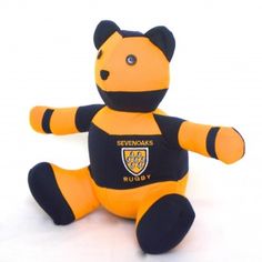 a yellow and black teddy bear sitting on top of a white surface with the words seffronics rugby written on it