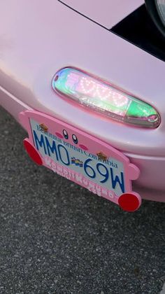 a close up of the license plate on a pink car