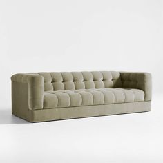 a beige couch sitting on top of a white floor