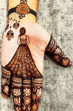 a woman's hand painted with henna and flowers on it, showing the intricate design