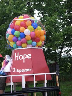 a large gummy machine filled with lots of balloons on top of it's stand