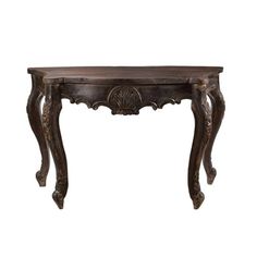 an antique wooden table with carvings on the top and legs, against a white background