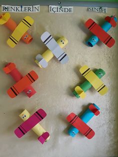 colorful paper airplanes are arranged on the wall