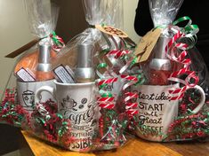 two coffee mugs wrapped in plastic and decorated with candy canes