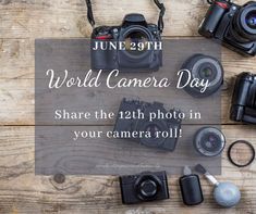 the world camera day poster is displayed on a wooden table with various cameras and accessories