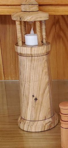 a wooden chair with a candle holder on top of it next to stacks of wood