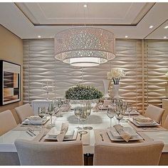 a dining room table set with place settings and flowers in vases on the centerpiece