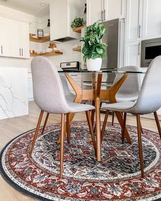 a table with chairs and a rug on the floor