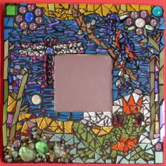 a colorful mosaic frame is shown with beads and stones on the bottom, along with an orange background