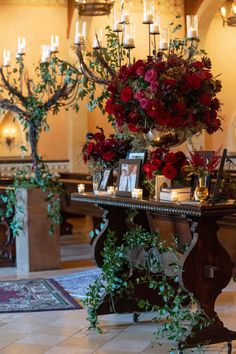 a table with flowers and candles on it in a room filled with chandeliers