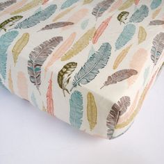 an image of a bed sheet with colorful feathers on the cover and bottom half of it