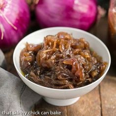 a white bowl filled with onions on top of a wooden table