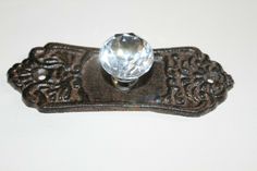 a metal object with a crystal stone on it's center and filigrees