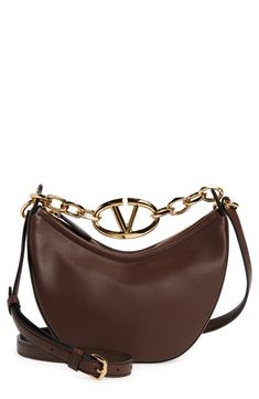 A gleaming chain centered with a VLOGO insignia spans the top of this hobo crafted from grained leather in a slouchy crescent silhouette. Top zip closure Chain top carry handle; removable, adjustable shoulder strap Leather Made in Italy Designer Handbags Elegant Brown Shoulder Bag With Metal Logo, Luxury Brown Shoulder Bag With Metal Logo, Luxury Brown Bag With Metal Logo, Brown Shoulder Bag With Metal Logo For Everyday, Chic Brown Bags With Metal Logo, Chain Top, Hobo Bag, Valentino Garavani, Crescent