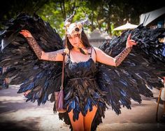 a woman dressed in black and blue with large wings