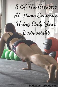 a woman is doing push ups on the floor with green and red balls behind her