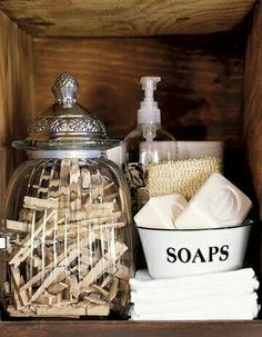 a wooden shelf with soaps, toothbrushes and other bathroom items in it