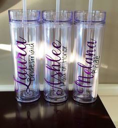 three personalized tumblers sitting on top of a table with straws in them