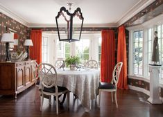 the dining room is decorated with orange curtains