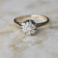 Vintage mid-century diamond cluster ring dating to about the 1950s. It has a raised design for a high-impact look. Each stone is about .05 ct for a ctw of .35 ct.  Era: c.1950s Markings: 14k, Makers mark (W in a diamond frame) Ring Size: 6.5 (your order comes with one free resizing by our jeweler) Condition: Excellent antique condition with minor surface wear from age  Shipping is free in the United States Follow on Instagram @LUXXORVintage Mid Century Ring, Vintage Diamond White Ring With Halo Setting, Vintage Diamond White Diamond Ring With Halo Setting, Classic Cluster Ring With Center Stone, Antique Cluster Diamond Cut Diamond Ring, Antique Cluster Diamond Ring With Diamond Cut, Classic Cluster Rings With Single Cut Diamonds, Vintage Yellow Gold Cluster Ring With Diamond Accents, Vintage Diamond White Cluster Ring With Diamond Cut