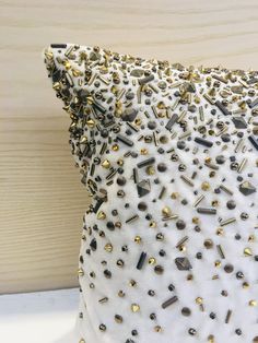 a white pillow with gold studs on it