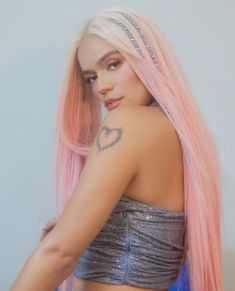 a woman with pink hair wearing a silver top