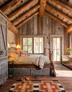 a bedroom with wooden walls and ceilings has a large bed in the center, along with an area rug on the floor