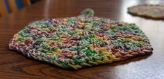 two crocheted coasters sitting on top of a wooden table