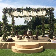 an outdoor seating area with flowers and greenery on the top, surrounded by stone steps