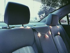 the interior of a car with christmas lights strung on it's dash board and seats