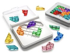 an assortment of colorful plastic objects on a white surface, including a game board and dices