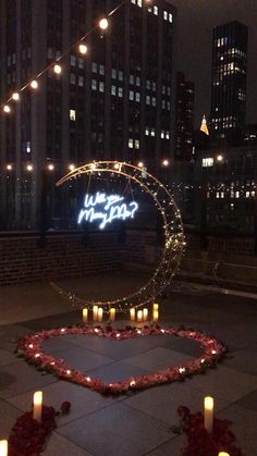 candles are lit in the shape of a heart on top of a circular area with a sign that says we love new york