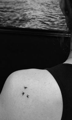 a woman's back shoulder with three small birds on it