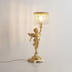 a golden angel lamp on a white background