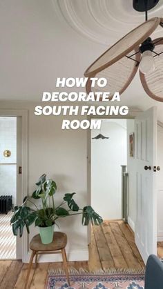 a living room with a ceiling fan and some plants on the table in front of it