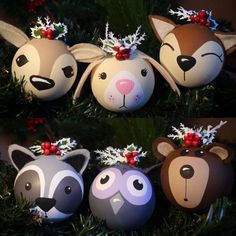 christmas ornaments made to look like animals with antlers on their heads and noses are hanging from a tree