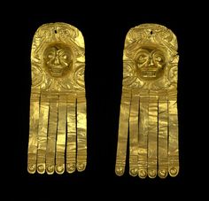 two gold earrings with designs on them, one in the shape of a face and another in the shape of a head