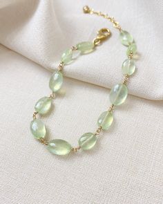 The color of these gorgeous prehnite gems reminds me of the sun shining through new spring leaves. They shimmer and glow with every movement, catching the light in the most enchanting way. I have wire-wrapped each faceted oval gem by hand in 14K gold fill, forming a simple, elegant chain. The extender allows for an adjustable fit for most wrists. Bracelet length: 7 inches plus 1-inch extender Materials: prehnite, gold fill Green Citrine Jewelry With Gemstone Accents, Elegant Faceted Chrysoprase Jewelry, Elegant Green Citrine Jewelry, Green Moonstone Jewelry With Natural Stones, Elegant Jewelry With Natural Stones And Chrysoprase, Elegant Chrysoprase Jewelry With Natural Stones, Green Moonstone Jewelry For Healing, Elegant Peridot Jewelry With Natural Stones, Elegant Adjustable Light Green Jewelry