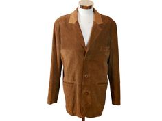 This 1980s Swedish vintage russet brown suede cost has a classic blazer style, with its notch collar (the upper lapel in tan leather), lightly padded shoulders, and three-button closure in front. The handsome  long leather jacket has three pockets on the front and is lined in a brown satin viscose fabric. Condition: Excellent (Professionally Cleaned ... soft and supple, with no stains, tears, wear spots, or weaknesses in the seams)  Size: 42 US/UK Brand label: Jofama (Made in Sweden) Material: Leather Chest = Best fit for 42 inches (106.68cm) Shoulder Width = 20 inches (50.8cm) Sleeve Length = 25.5 inches (64.77cm) Jacket Length = 32 inches (81.28cm) Brown Suede Long Sleeve Blazer, Brown Single Breasted Suede Blazer, Vintage Brown Blazer With Lapel Collar, Brown Suede Single Breasted Blazer, Brown Single-breasted Suede Blazer, Brown Suede Blazer For Work, Long Leather Jacket, Uk Brands, Blazer Style