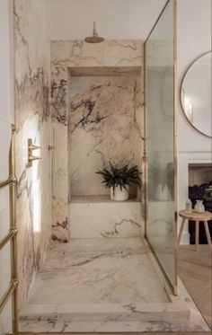 a bathroom with marble walls and flooring in white, gold and black colors is shown