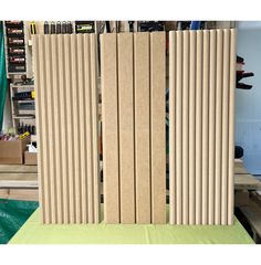 two wooden panels sitting next to each other on top of a green cloth covered table