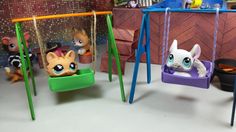 two toy swings with cats on them in a playroom area, one has a cat swing and the other has a kitten doll