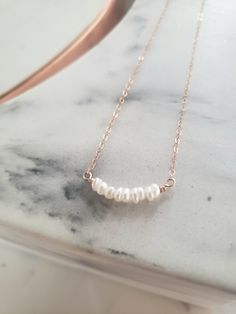 * Simple and sweet, great for layering with other necklaces for a feminine touch. Would also be beautiful for bridesmaids or a bride! * White freshwater pearls are wrapped in a softly curved bar and finished with a shimmery and dainty chain. * Cable chain is delicate yet strong and finished with an oval lobster clasp. * Made from top quality water proof materials. No green skin or color fading. * Nickel free. ~M A T E R I A L S ~ Choose from- * 925 Sterling silver *14k Gold fill *14k Rose gold f 14k Rose Gold Filled Necklaces With Pearl Pendant, Rose Gold 14k Gold-filled Necklace With Pearl Pendant, Feminine Rose Gold Necklace With Pearl Drop, Feminine Rose Gold Pearl Drop Necklace, Dainty Rose Gold Pearl Pendant Necklace, Feminine Rose Gold Necklace With Pearl Chain, Feminine Rose Gold Pearl Chain Necklace, Feminine Rose Gold Pearl Necklaces, Delicate Rose Gold Pearl Necklace