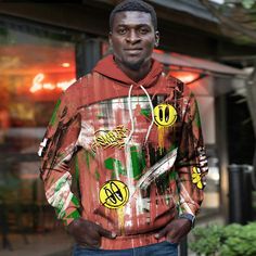 a man standing in front of a building wearing a hoodie