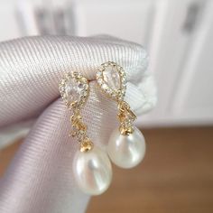 These stunning earrings feature lustrous oval pearls, accented with sparkling water drop-shaped zircons. The 18K gold plating adds a touch of modernity and makes them long-lasting, non-tarnishing for years! Pearl Type: Freshwater Pearls Pearl Quality: [Shape]: Oval [Size]: 8-9mm [Blemish]: None [Luster]: High Material: 18k Gold Plated Brass Note: Every pearl is unique. Items may vary from the pictures. Gold Plated Teardrop Pearl Earrings, Gold-plated Teardrop Pearl Earrings, Oval Pearl Charm Earrings For Wedding, Luxury Oval Pearl Drop Earrings, Elegant Oval Gold Plated Earrings, Elegant Gold Plated Teardrop Earrings For Formal Occasions, Gold Pearl Teardrop Earrings For Formal Occasions, Gold Oval Bridal Earrings, Elegant Oval Teardrop Earrings For Formal Occasions