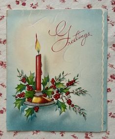 an old fashioned christmas card with a lit candle and holly wreath on it's side