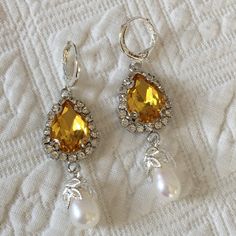 "Handmade Yellow Teardrop Shaped Stone Surrounded by Clear Rhinestones With an Oval Real Pearl Set in a Leaf Design. Stunning Eye Catching Yellow Stone in Feminine Style Setting. Great for modern wear or costuming. 925 Silver Plated Loop Lever Back Pierced Earrings. Pair of reproduction historic earrings, New. Period appropriate for 18th and 19th Century dressing. Good for modern wear, also. Size: 9/16\" X 3/4\" Large Stone Setting, 1 1/2\" Dangling Length, 1 1/2 cm X 4 cm. For other vintage jew Jeweled Dangle Bridal Earrings, Elegant Yellow Dangle Clip-on Earrings, Silver Teardrop Clip-on Crystal Earrings, Silver Teardrop Crystal Clip-on Earrings, Dangle Teardrop Gemstone Earrings For Wedding, Gemstone Teardrop Dangle Earrings For Wedding, Gemstone Dangle Teardrop Earrings For Wedding, Wedding Dangle Teardrop Gemstone Earrings, Silver Teardrop Cubic Zirconia Clip-on Earrings