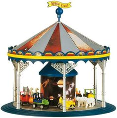 a toy carousel with horses and carriages on it's sides, in front of a white background