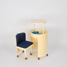 a chair next to a small table with a bowl on it and a stool in front of it