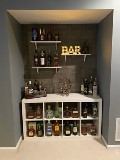 a bar with shelves filled with liquor bottles and glasses on it's side wall